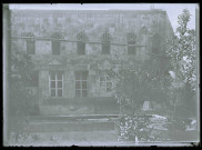 Façade d'habitation avec son jardin et sa fontaine.