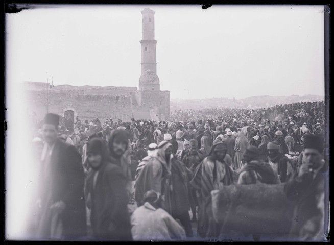 Foule au pied de la citadelle d'Alep (Syrie) avec un minaret en arrière-plan.