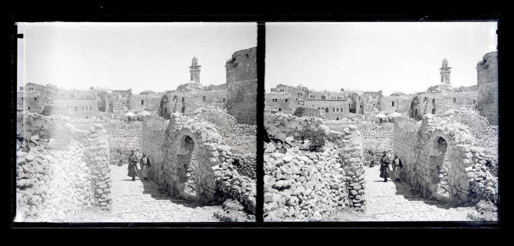 Enfants dans les ruelles d'un village, au loin un minaret.