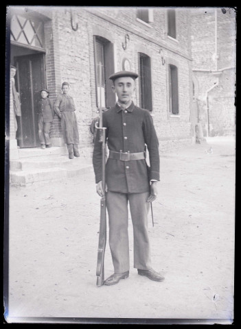Militaire français armé d'un fusil à baïonnette dans la cour de la maison fermière d'Orgeville (Eure).