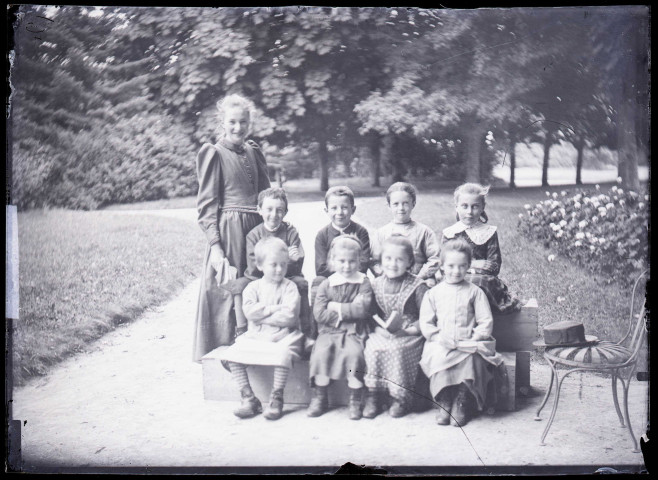 Melle Bonjean avec un groupe d'enfants dans un jardin.