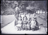 Melle Bonjean avec un groupe d'enfants dans un jardin.