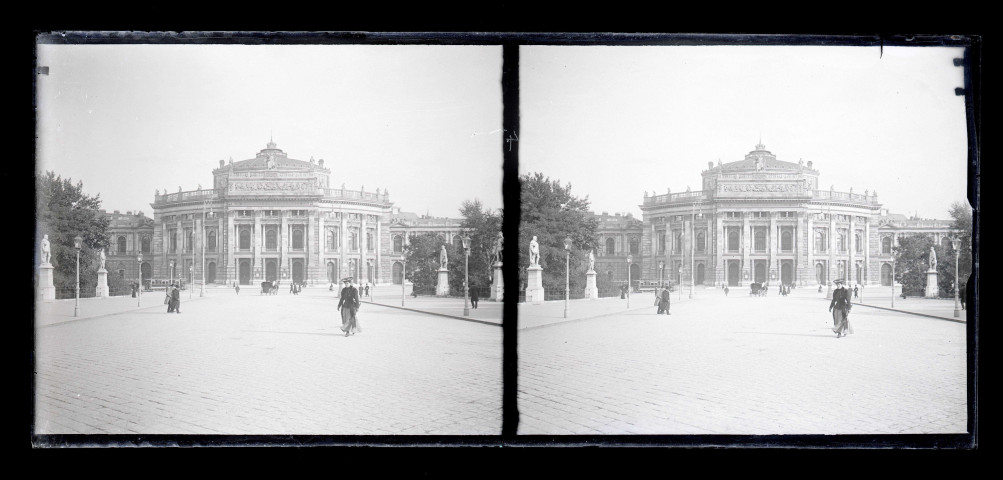 Bâtiment public au bout d'une avenue bordée de statues.