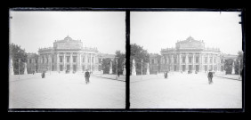Bâtiment public au bout d'une avenue bordée de statues.