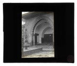 Cour intérieure carrelée à arcades avec fontaine.