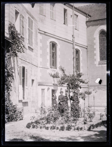 Femmes au pied d'une habitation.