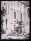 Femmes au pied d'une habitation.