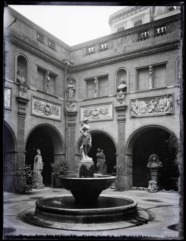 Cour intérieure de musée avec statues et fontaine.