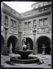 Cour intérieure de musée avec statues et fontaine.