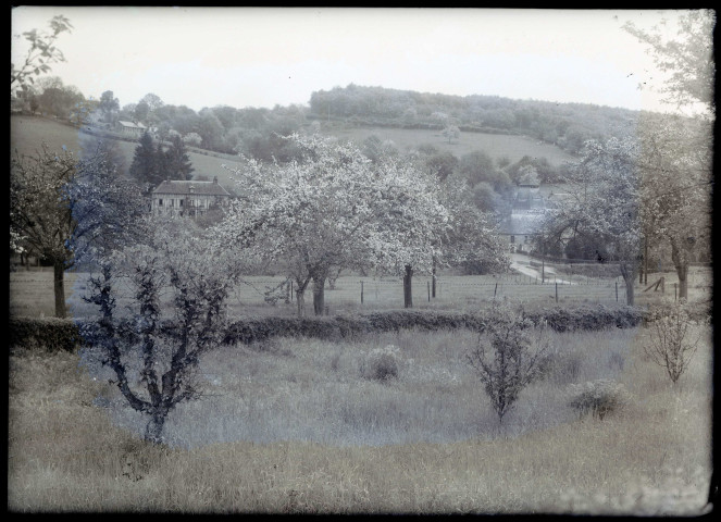 Vue sur le Prieuré de Rosay-sur-Lieure (Eure) depuis un verger en fleurs.
