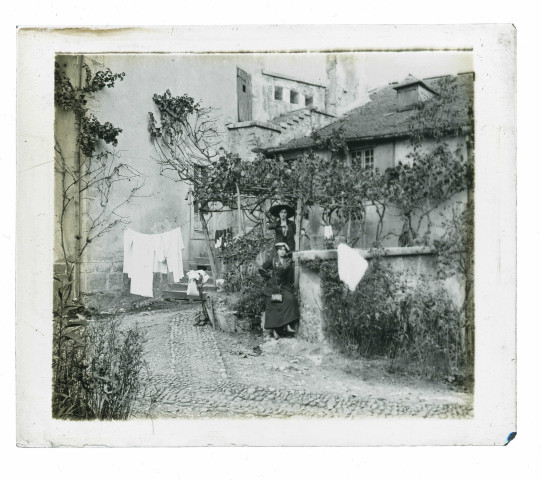 Femmes posant devant une maison dans les ruelles d'un village des environs de Lourdes (Hautes-Pyrénées).