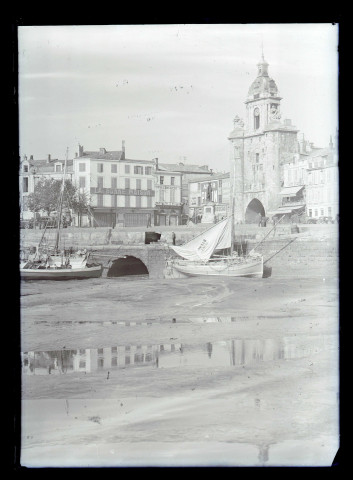 Bateaux de pêche au port à marée basse et tour de la Grosse-Horloge de La Rochelle (Charente-Maritime).