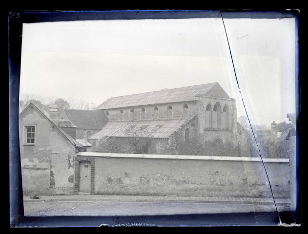 Bâtiment religieux aux vitraux déposés et fenêtres murées.