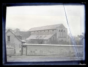 Bâtiment religieux aux vitraux déposés et fenêtres murées.