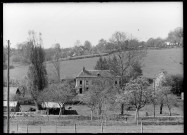 Vue sur un prieuré de campagne depuis un verger.