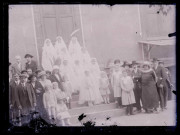 Communiantes et familles sur le perron d'une habitation.