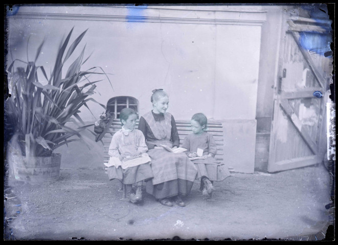 Jeunes filles assises sur un banc dans un jardin.