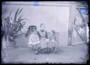 Jeunes filles assises sur un banc dans un jardin.