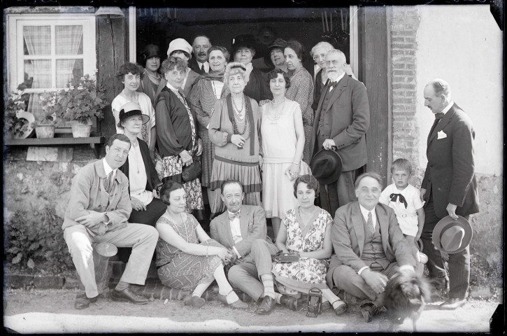 Portrait de famille sur le perron d'une habitation. (on remarque posé au sol un appareil photographique à soufflet).