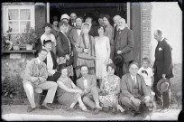 Portrait de famille sur le perron d'une habitation. (on remarque posé au sol un appareil photographique à soufflet).