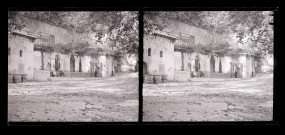 Façade d'un bâtiment attenant une paroi rocheuse.