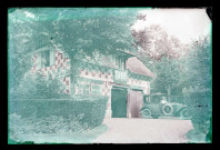 Manoir et homme au volant de son automobile.
