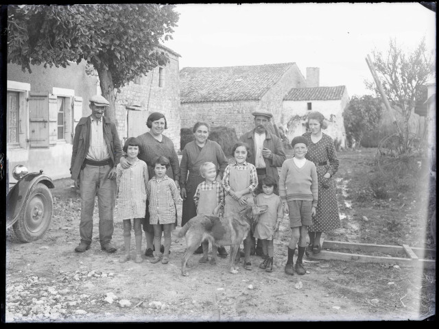 Famille de paysans devant leur ferme.