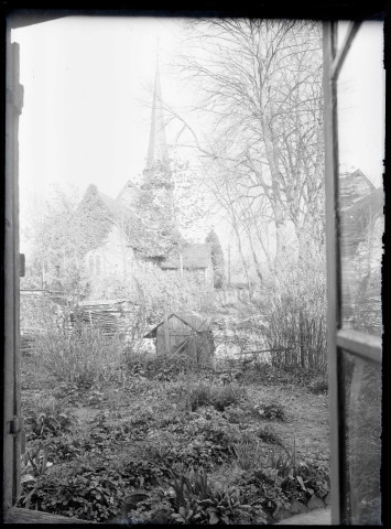 Vue de l'église de Ménesqueville (Eure) depuis un potager.