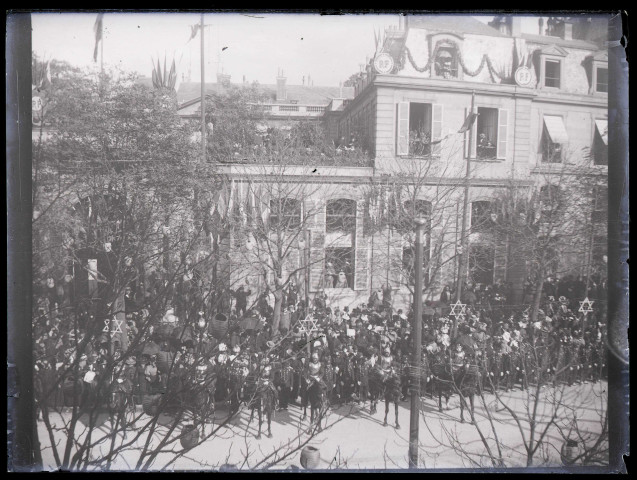 Défilé de troupes militaires devant la façade d'un bâtiment officiel.