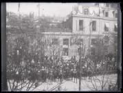 Défilé de troupes militaires devant la façade d'un bâtiment officiel.