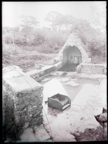 Fontaine bretonne avec lavoir et statue de saint.