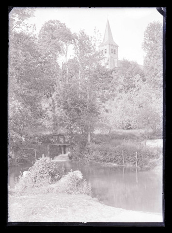 Vue sur la campagne et la clocher d'une église.
