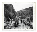 Enfant sur un sentier menant à un village à flanc de montagne.