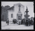 Villageois à la fontaine sur la place d'une église sicilienne.