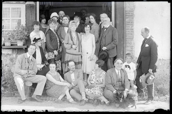Portrait de famille sur le perron d'une habitation. (on remarque posé au sol un appareil photographique à soufflet).