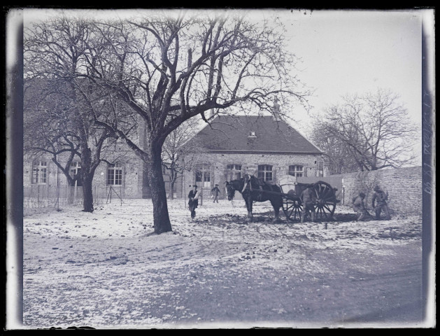 Hommes et leur cheval de trait au travail devant un bâtiment le 21 mars 1899.