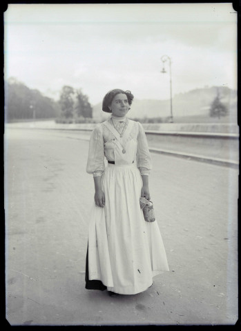 Jeune femme avec sa gourde d'eau bénite sur une route de Lourdes (Hautes-Pyrénées).