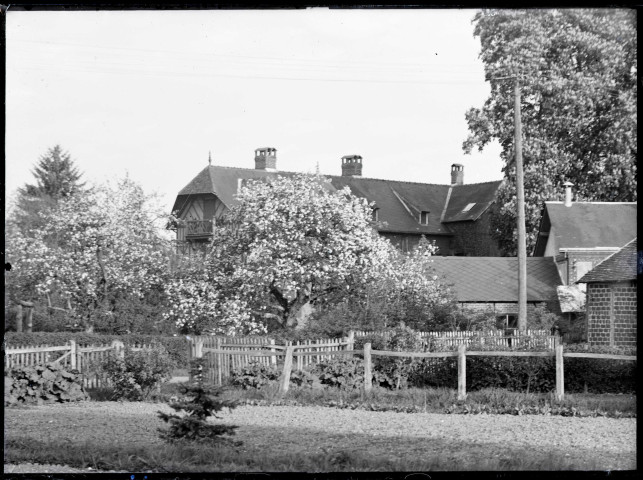 Manoir normand et verger en fleurs.