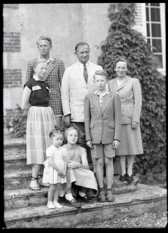 Portrait de famille sur le perron d'une maison.