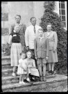 Portrait de famille sur le perron d'une maison.