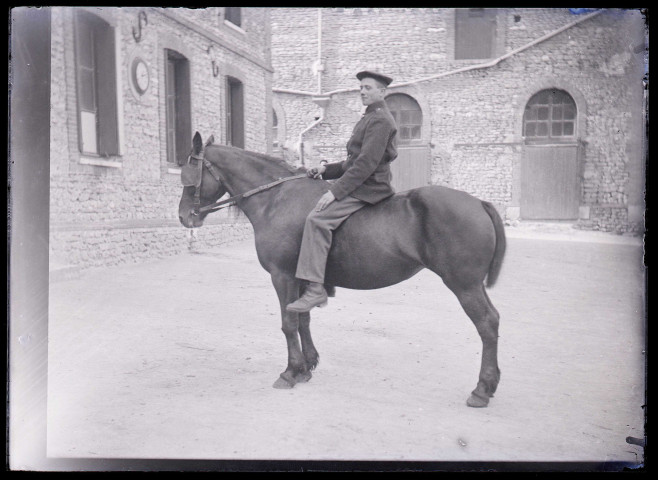 Militaire français à cheval dans la cour de la maison fermière d'Orgeville (Eure).