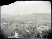 Vue sur une vallée avec un château, une chapelle et un ancien cimetière.