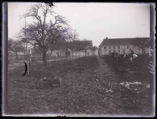 Hommes au travail dans le jardin d'une habitation en décembre 1898.
