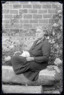 Rachel (Bretocq) assise avec un lapin sur les genoux dans le jardin.
