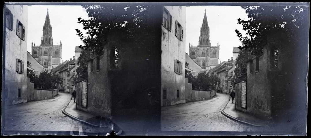 Flèche d'une église d'Alsace vue depuis une rue.