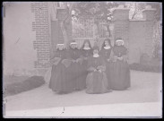 Religieuses devant la grille d'un bâtiment.