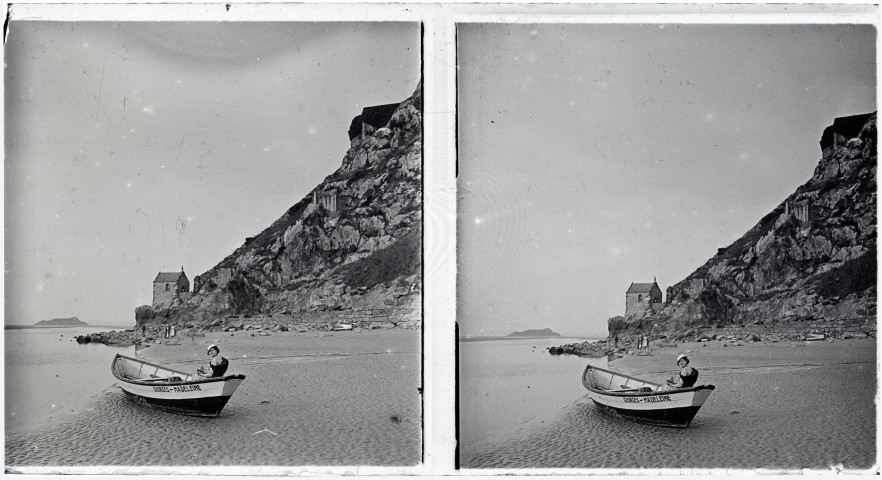 Femme à bord d'une barque échouée sur le sable près de la chapelle Saint-Aubert au Mont-Saint-Michel (Manche).