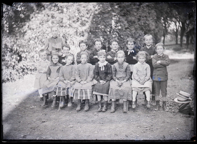 Melle Bonjean avec un groupe d'enfants dans un jardin.