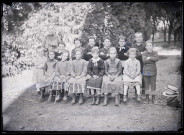 Melle Bonjean avec un groupe d'enfants dans un jardin.