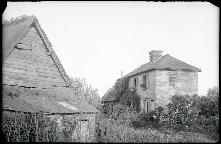 Femme posant dans un jardin sur le devant d'une maison de la campagne de Rosay-sur-Lieure (Eure).